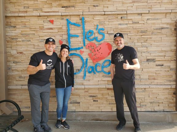 3 people hanging out in front of the Ele's Place sign.