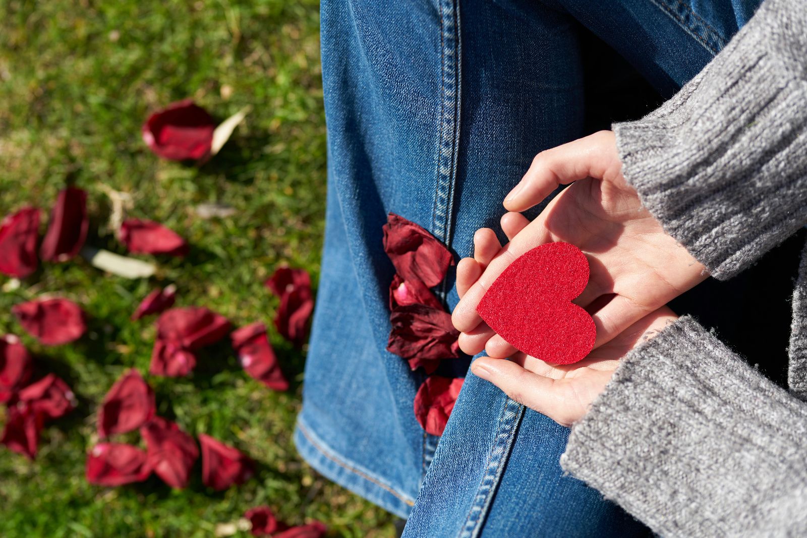 Image of person's hands holding a red heart.